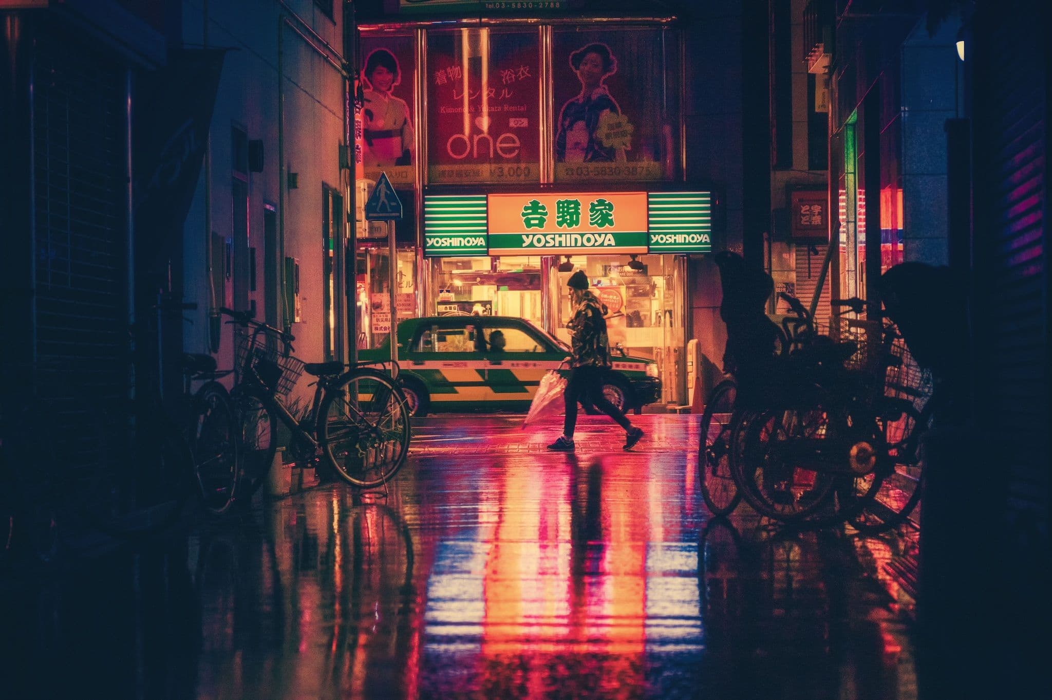 Night Passage. A lone commuter crosses a rain-lit city while reflections quietly distort the route home.